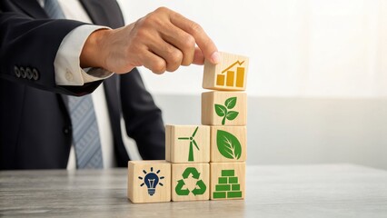 A businessman in a suit stacks wooden blocks with sustainability icons, symbolizing eco-friendly business growth, green energy, and corporate responsibility.