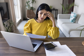 Young Indian woman feel stressed due to financial issues, looks concerned about money losses, budget issues, shortage of money to pay utility bills, received higher-than-expected invoices for payment