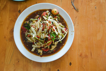 Thai dish called Som Tum, also known as papaya salad. It is made from finely shredded green papaya, mixed with green beans, tomatoes, and other fresh vegetables.