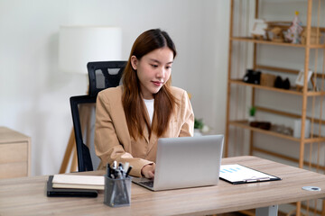 Young business woman using computer at desk in marketing