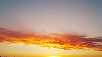 Fototapeta premium Fiery Orange Sunset With Dramatic Cloudscape And Golden Light On The Horizon Illuminating The Evening Sky