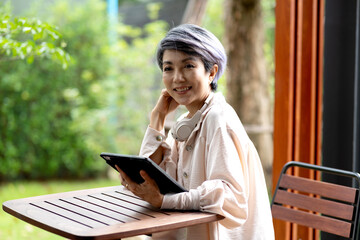 Fototapeta premium Elder business woman use tablet be comfortable in the garden