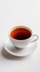 Warm tea rests delicately in a sleek white cup, inviting a moment of serenity. The rich amber liquid reflects light, promising relaxation and comfort amidst a calm atmosphere