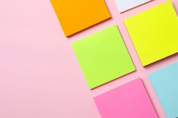 Multicolored paper stickers on a pink background
