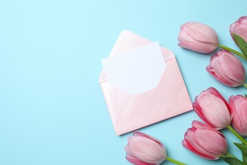Beautiful fresh tulips with paper envelope on color background