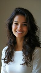 Fototapeta premium A woman with long hair is smiling and wearing a white shirt
