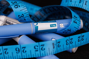 An artistic arrangement of semaglutide injection pens and a sewing tape measure, representing...
