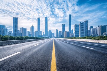 Fototapeta premium Wide empty highway leading to modern city skyline with skyscrapers and blue sky