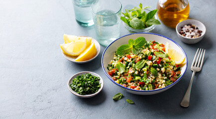 Tabbouleh salad in a bowl. Grey background. Copy space. Close up.
