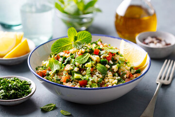 Tabbouleh salad in a bowl. Grey background. Close up.