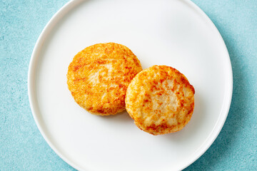 Chicken patties, cutlets on a white plate. Blue background. Close up. Top view.