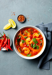 Tom Yum soup with prawns in a bowl. Grey background. Top view.