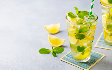 Lemonade, lemon ice tea, mint cocktail in glass. Blue background. Copy space. Close up.