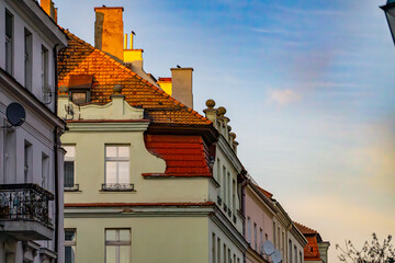 old urban architecture at sunset. blocks and residential buildings in the city against the background of a beautiful sky. renovated residential tenement houses.