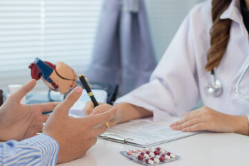 A young man with heart disease visits a female doctor for advice on heart disease treatment. The...