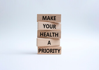 Health symbol. Wooden blocks with words Make your health a Priority. Beautiful white background. Health concept. Copy space.