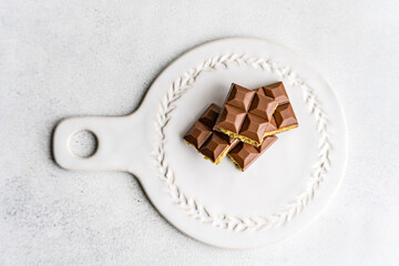Overhead view of a Dubai chocolate bar filled with pistachio paste on a serving plate