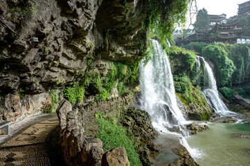 Beautiful waterfall and ancient village at Furongzhen or Furong ancient town in Hunan, China.