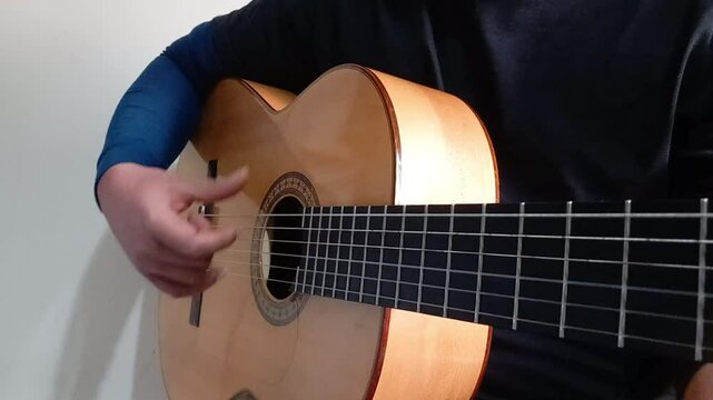 

A close up shot from the guitarist right hand that practice flamenco technique (abanico) 
