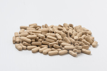 Oval brown pills as a dietary supplement on a white table