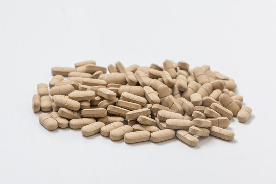 Oval brown pills as a dietary supplement on a white table