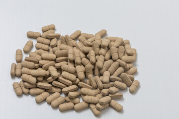 Oval brown pills as a dietary supplement on a white table