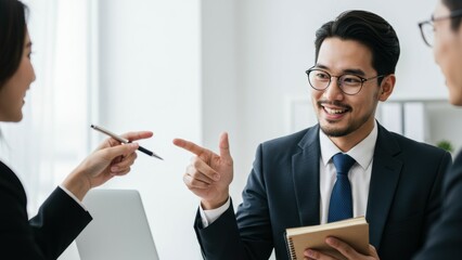 Asian businessman discussing with Caucasian businesswoman in urban office, emphasizing teamwork and communication