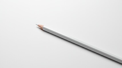 White pencil placed diagonally on a blank surface, emphasizing creativity and artistic pursuits