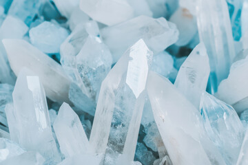 Crystal clear close up of shimmering quartz mineral points with natural geometric structures and soft blue lighting
