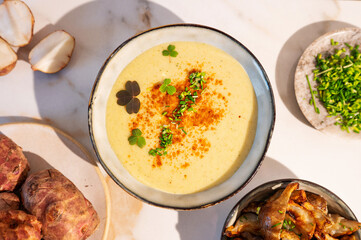 A creamy bowl of Jerusalem artichoke puree soup, garnished with herbs.