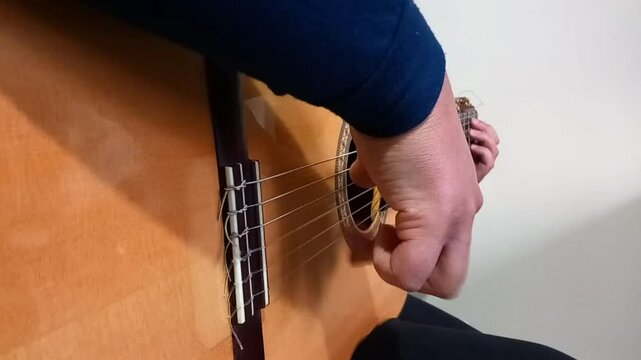 A closeup shot of the guitarist right hand from right angle side that play tremolo and chanage guitar chords easily