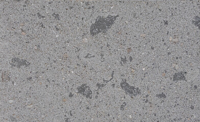 Gray concrete wall showing fine gravel and dark spots texture background