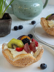 Dolce cestino di pasta sfoglia con panna e frutta fresca sul tavolo della colazione