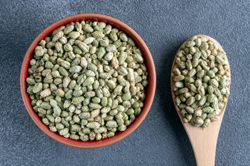 Fototapeta premium A bowl filled with a pile of natural dried thyme, alongside a spoon containing thyme seeds