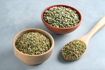 A bowl full of dried and ground natural mountain thyme on light background
