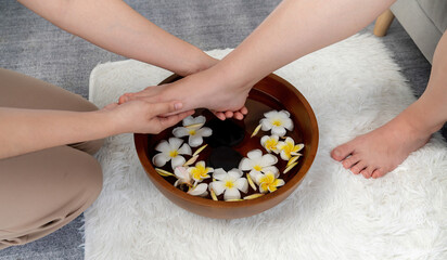 Woman indulges in blissful foot massage at luxurious spa salon while masseur give reflexology therapy in gentle day light ambiance resort or hotel foot spa. Quiescent