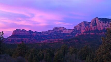 Fototapeta premium Serene Sunset Over Majestic Mountain Range with Vibrant Pink and Purple Sky Illuminating the Rocky Peaks and Lush Forest Below in a Scenic Landscape