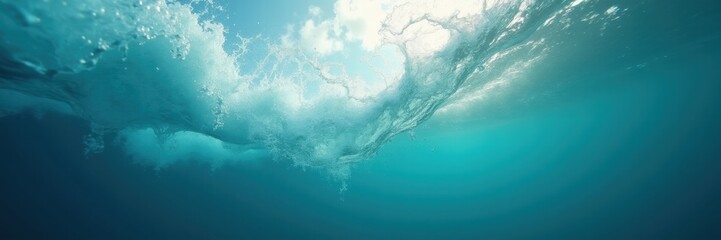 Obraz premium Beneath the surface, sunlight pierces through tranquil ocean waves, creating a serene underwater scene filled with vibrant blue hues.