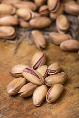 Pistachio nuts on a wooden trencher, natural and healthy snack concept