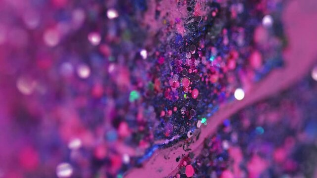Vertical video. Liquid shimmer texture. Glitter paint spill. Blur purple pink color shiny sequin particles emulsion fluid ink drip motion abstract art background with bokeh lights.