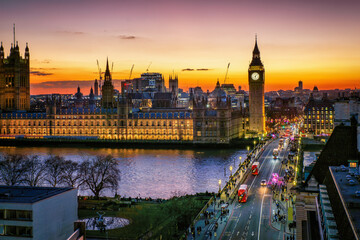 Elevated view of the illuminated Westminster Palace and Big Ben clock tower in London during dusk with street and people traffic, England