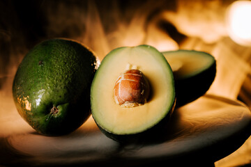 Fresh avocado cut open showcasing creamy texture on dark background with warm light highlighting details