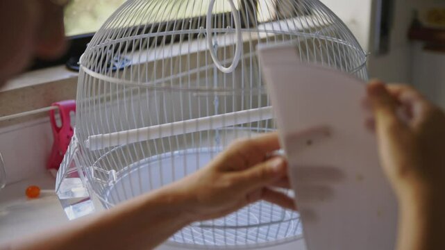 Woman opening a bird cage door