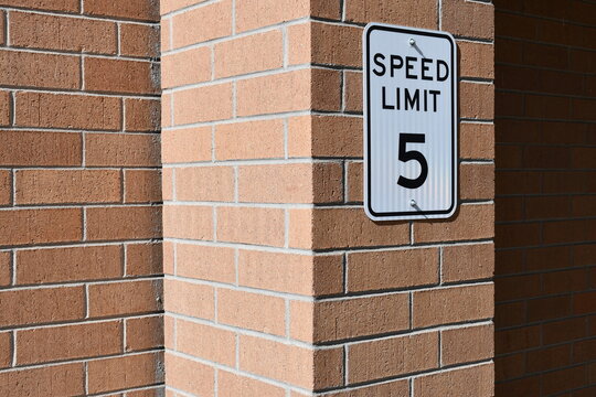 Speed limit sign on parking garage. 5mph posted on wall.