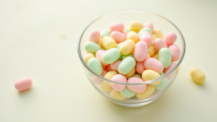 A clear glass bowl filled with colorful dye-free candies on a light background.