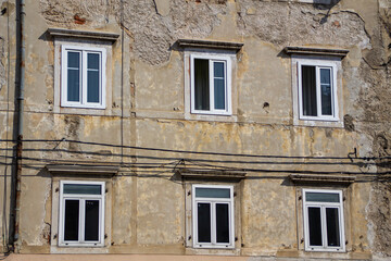 Brand new abs plastic windows on an very old house with crumbling facade
