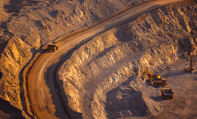 Banner industry, heavy industrial dump truck transports copper and gold ore in open pit mine, sunset © Parilov