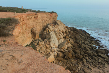 Crumbling cliff face overlooking the ocean at dawn