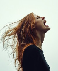 Woman screams with hair flowing in dramatic profile view