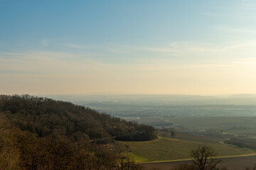Quiet landscape view over rolling hills under a clear sky during late afternoon in a rural area
